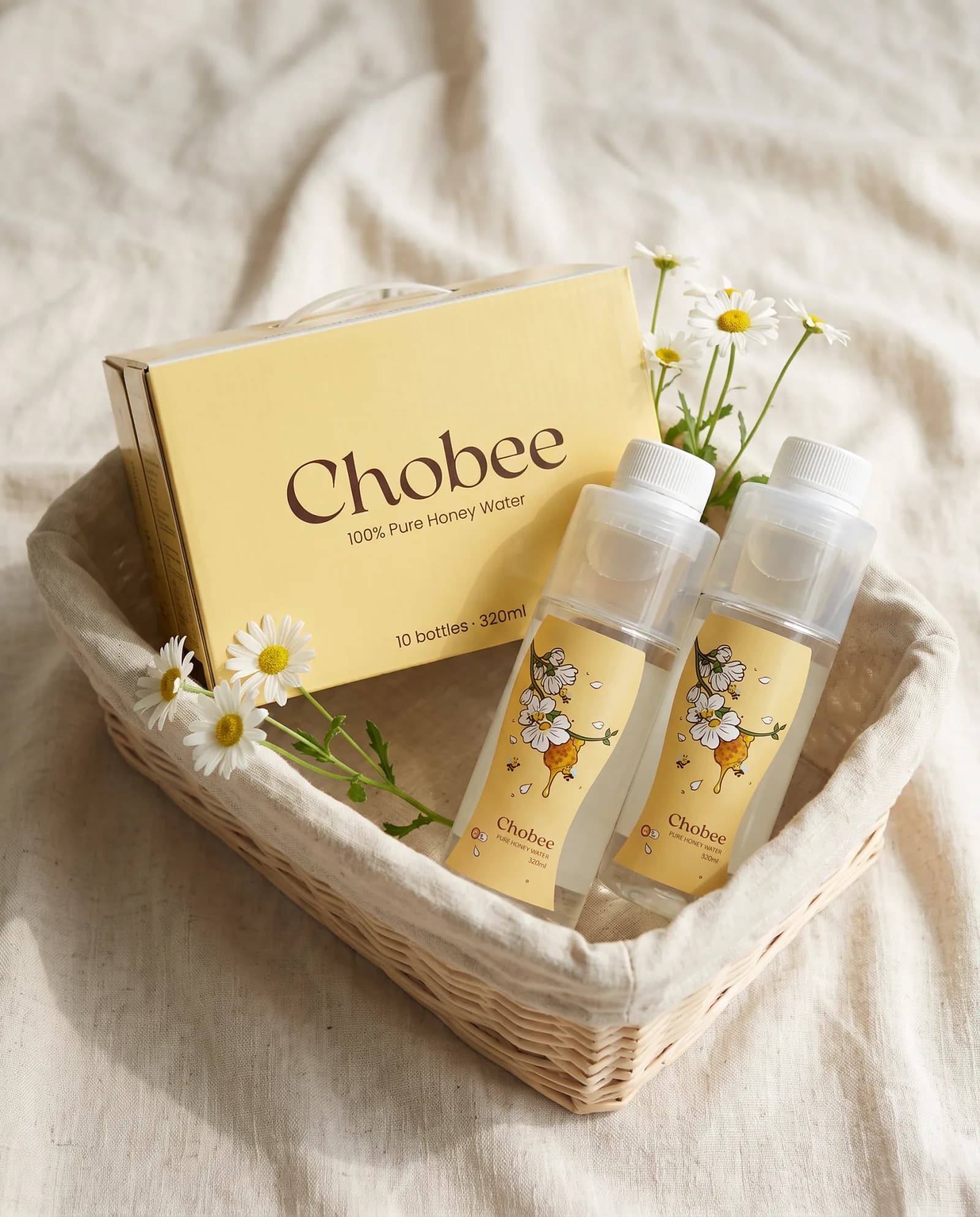 A CHOBEE box of 10 and two bottles of Pure Honey Water in a woven basket