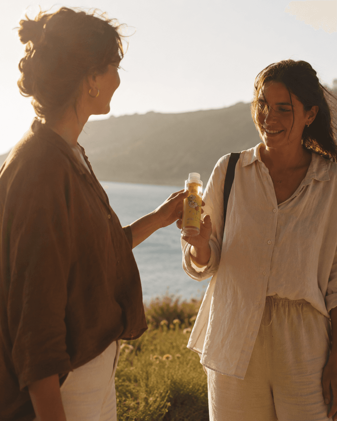 Two friends sharing CHOBEE honey water outdoors